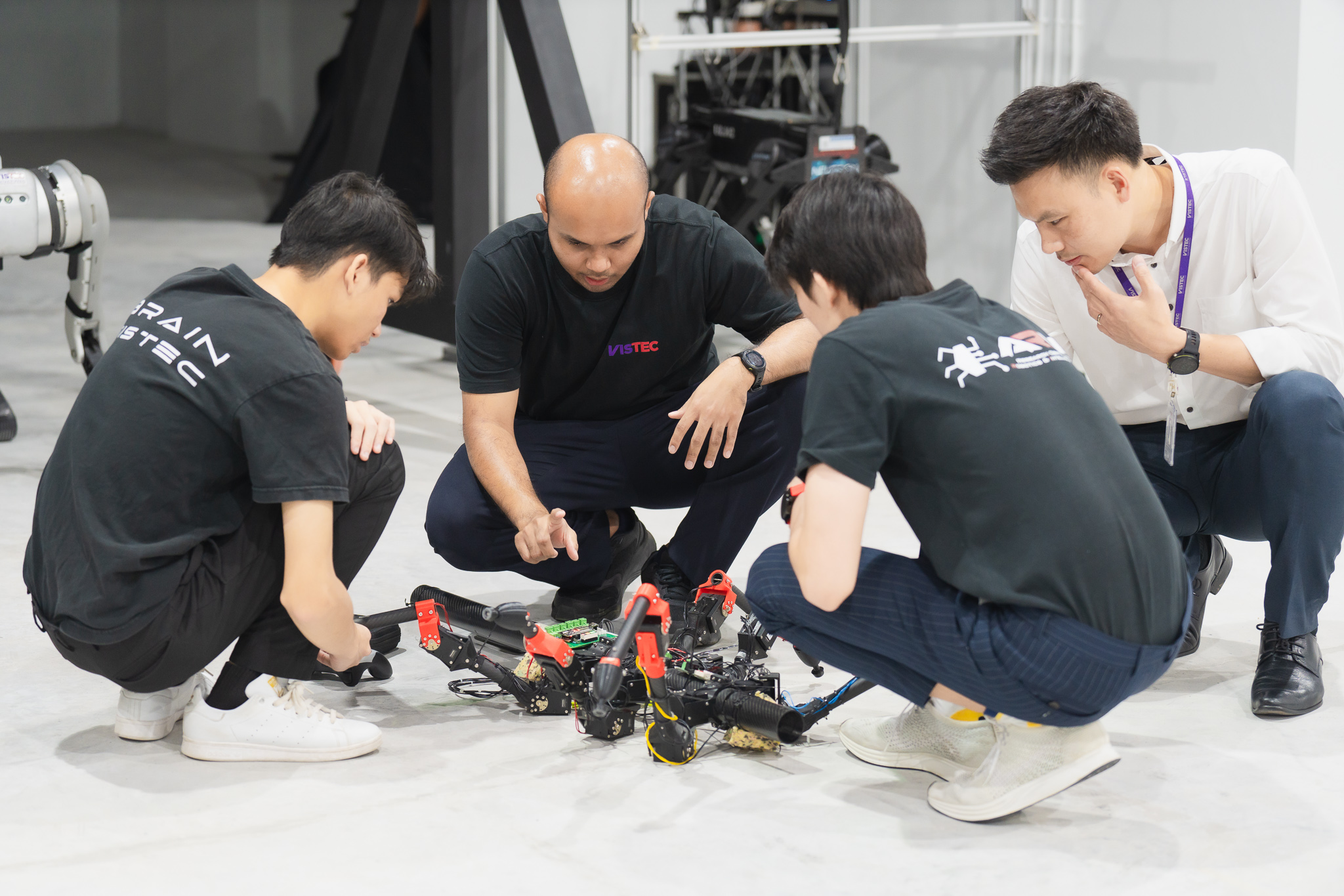 BRAIN VISTEC lab members working on a legged robot